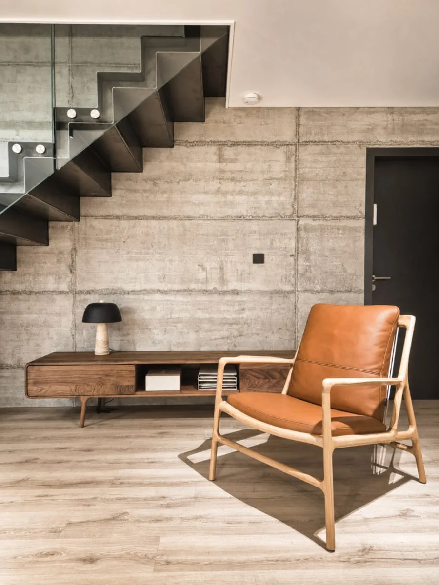 Détail showroom — fauteuil cuir et béton texturé